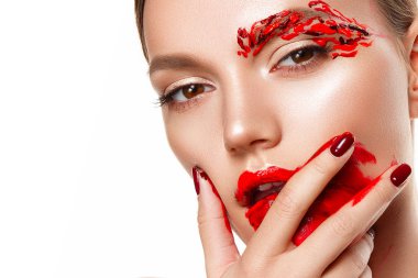 Genç bir kadın yüzüne dokunuyor