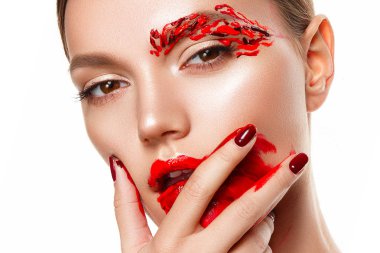 Genç bir kadın yüzüne dokunuyor