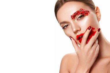 Genç bir kadın yüzüne dokunuyor