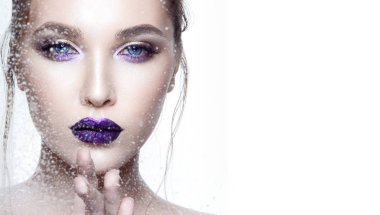 Genç model beyaz arka plan üzerinde mor parlak ruj ile portresi