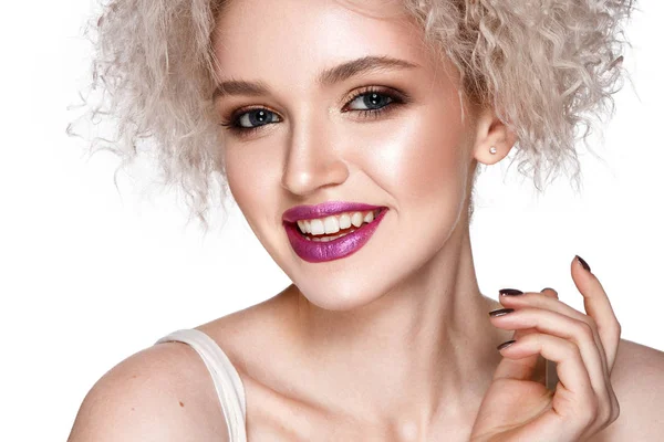 微笑的年轻模型卷曲的发型和粉红色的口红摆在白色背景 图库图片