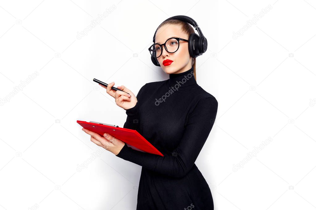 Woman in black with headphones and red lips posing with red board on white background