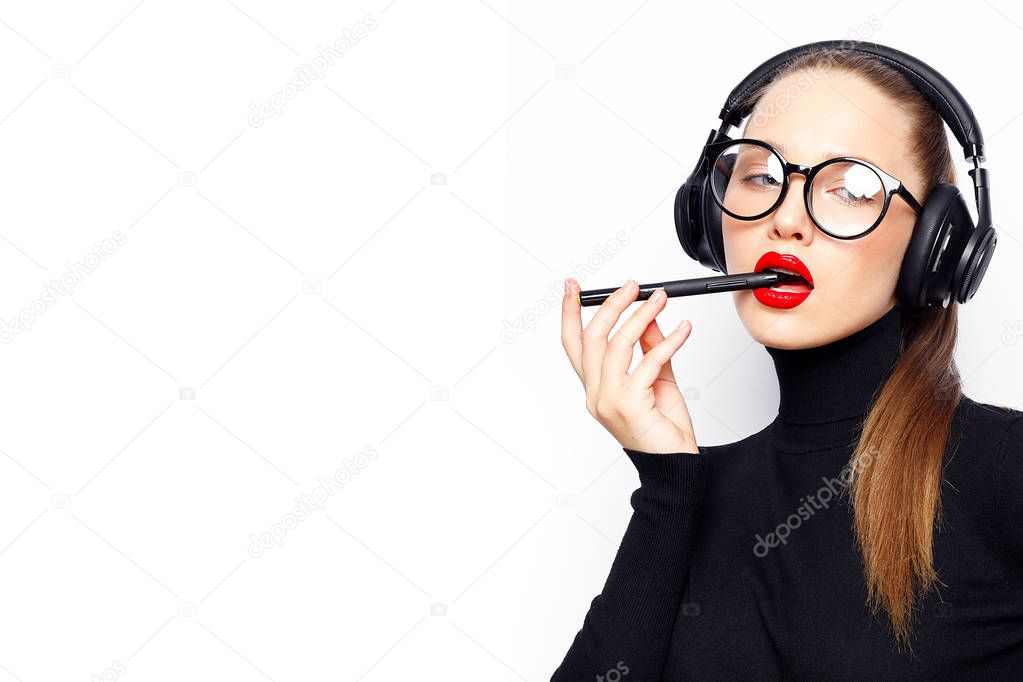 Young woman in headphones and red lips posing against white background