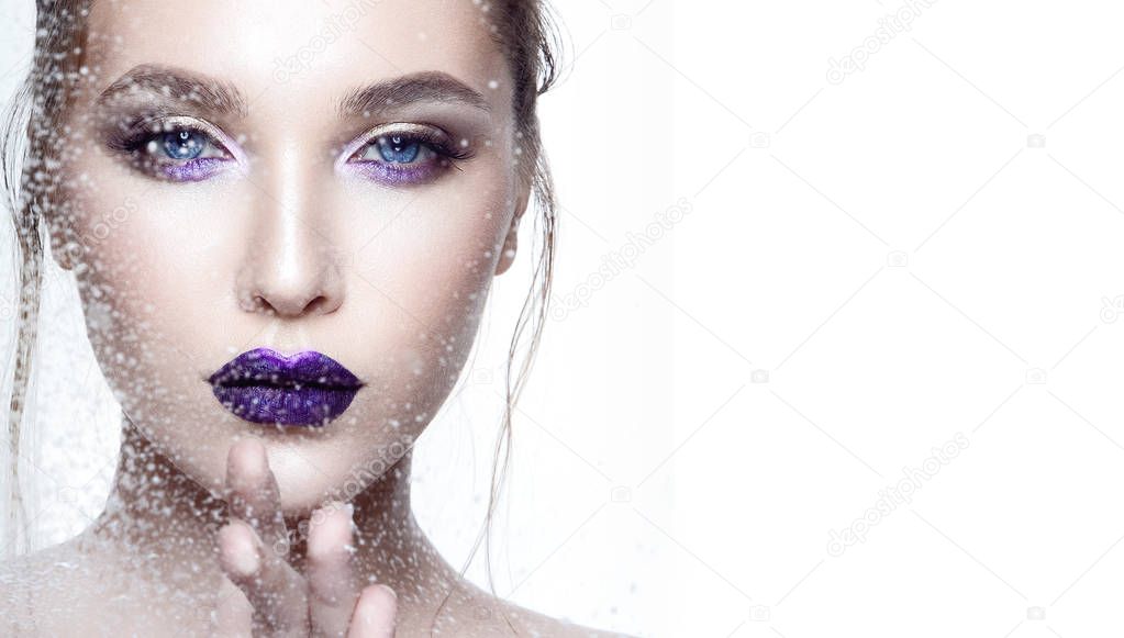 Portrait of young model with violet glossy lipstick on white background