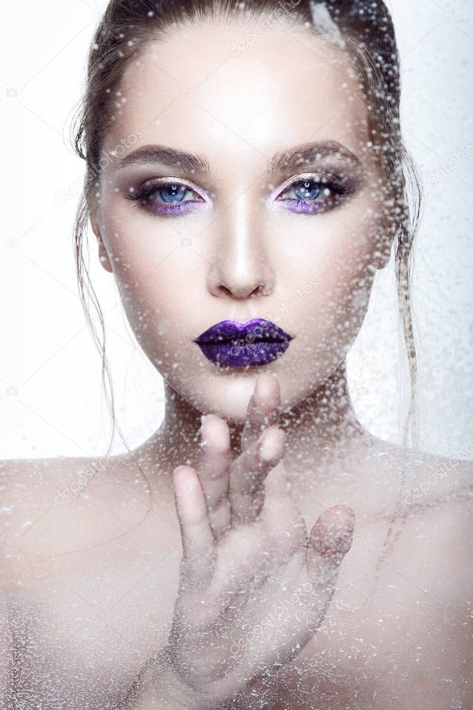 Portrait of young model with violet glossy lipstick on white background