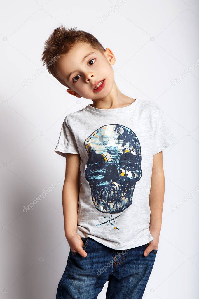 Young boy in t-shirt with print posing on white background in studio