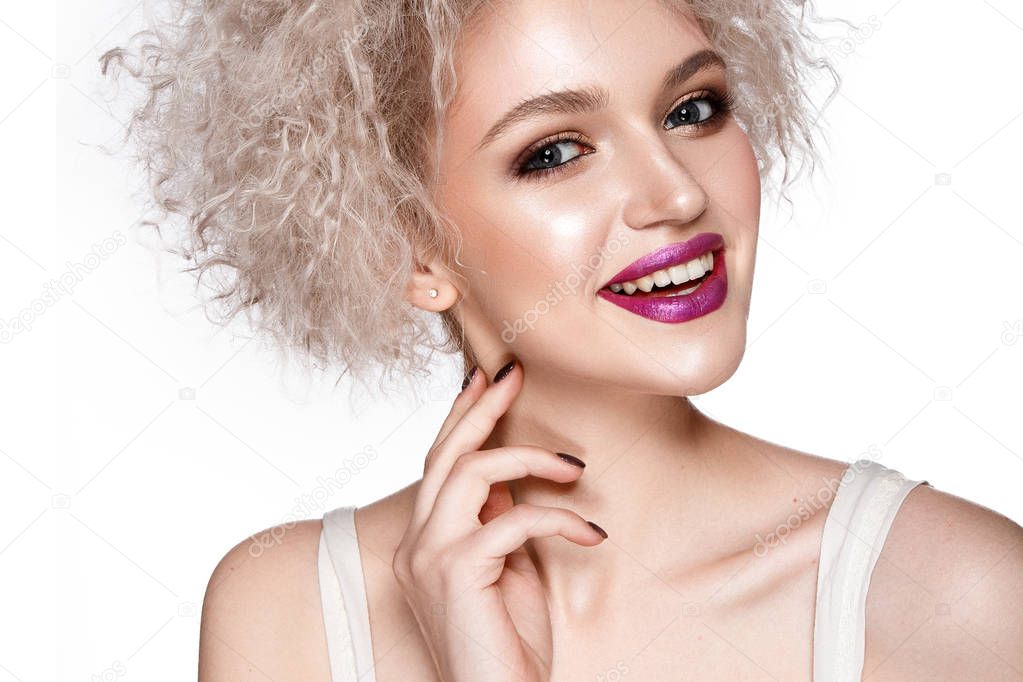 Smiling young model with curly hairstyle and pink lipstick posing on white background
