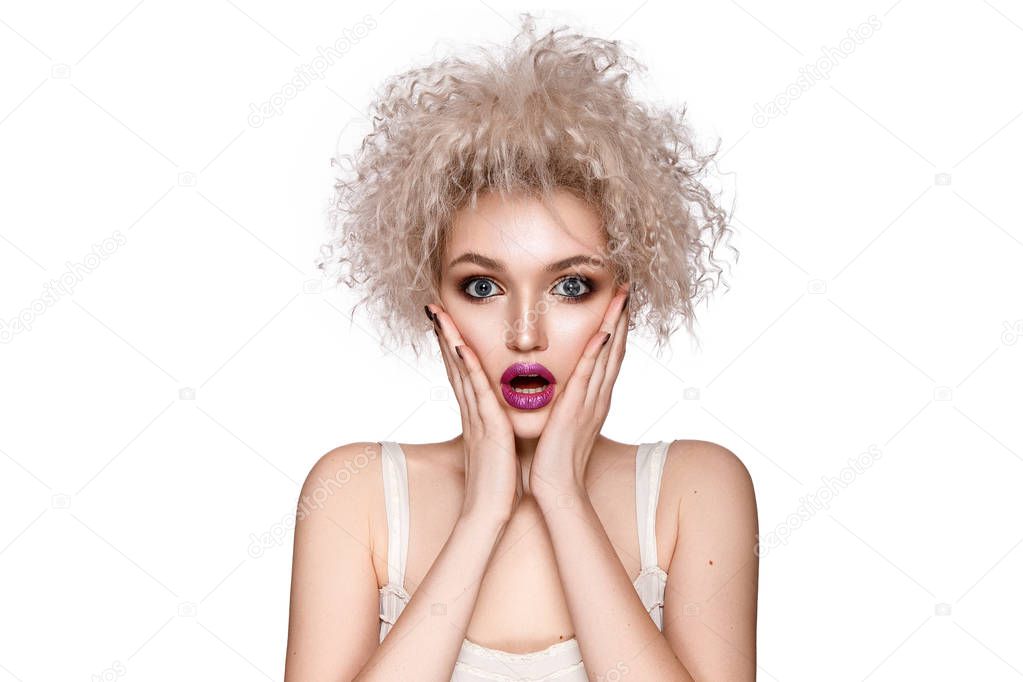 Surprised curly model with pink lips posing on white background
