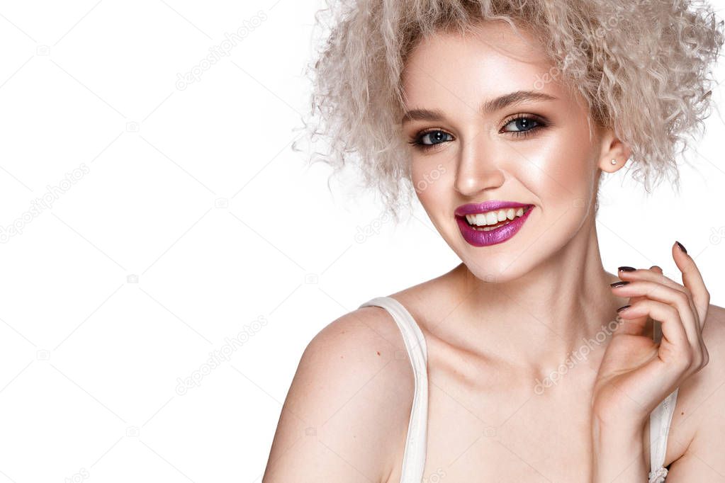 Smiling young model with curly hairstyle and pink lipstick posing on white background