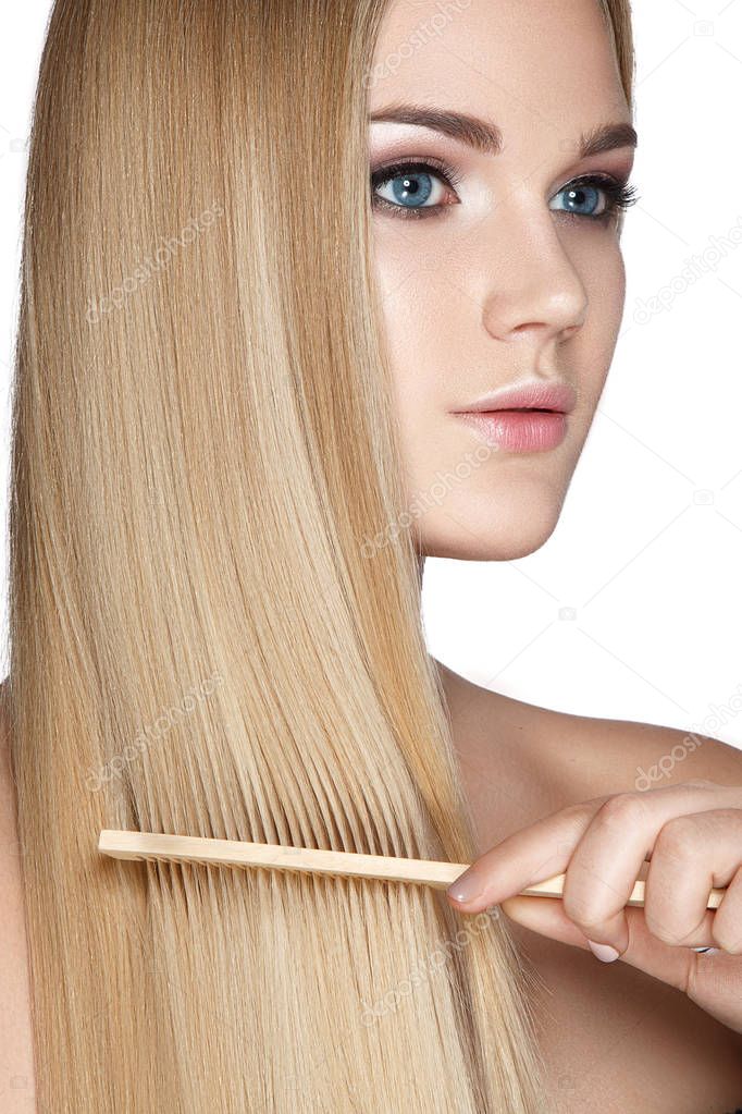 Portrait of blonde woman with comb on white background