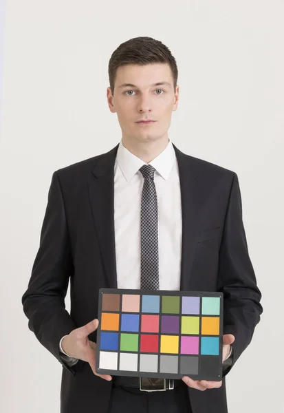 Young photographer holding color checker card — Stock Photo, Image