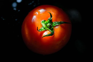 Siyah arka planda, güneş domates üzerinde kırmızı domates