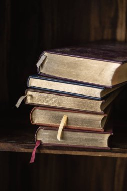 Eski tozlu kitaplar, ahşap rafta klasik kitaplar.