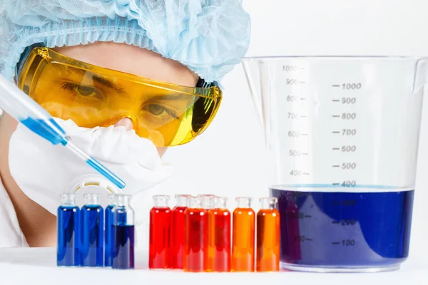 Студент з піпеткою, захисний одяг, окуляри в хімічній лабораторії — стокове фото