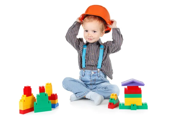 Kleine jongen in een rode bouw veiligheidshelm op witte achtergrond — Stockfoto