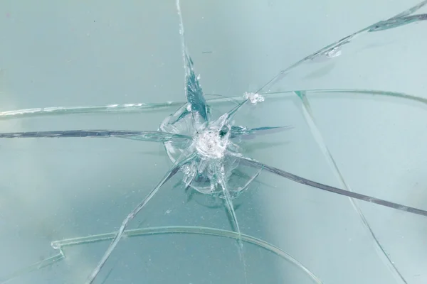 Hoyo de bala de armas de fuego en el vidrio de las balas, grietas de fondo — Foto de Stock