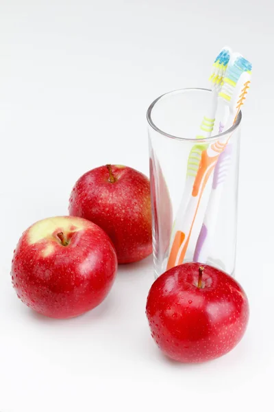 La manzana con el cepillo de dientes, sobre blanco. conceptos de cuidado dental — Foto de Stock