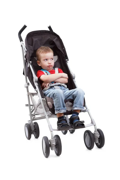 Serious child in a baby carriage on a white background — Stock Photo, Image