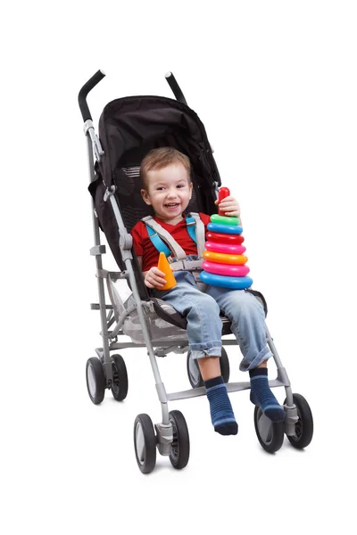 Smiling child is sitting in pram playing toy Royalty Free Stock Images