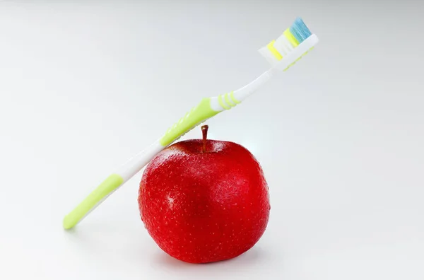 Toothbrush with apple, on white background. — Stock Photo, Image