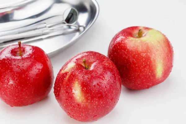 Manzanas rojas y herramientas dentales aisladas en blanco — Foto de Stock