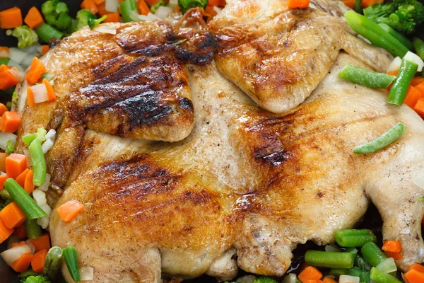 Whole grilled chicken with vegetables in a frying pan — Stock Photo, Image