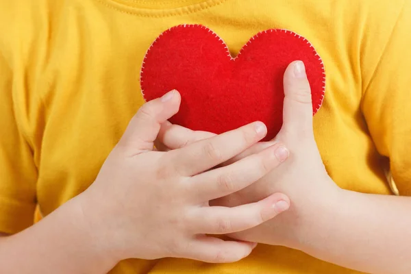 Lachende jongen houdt een rood hart beeldje. symbool van de liefde, familie,. Concept van de familie en kinderen. — Stockfoto