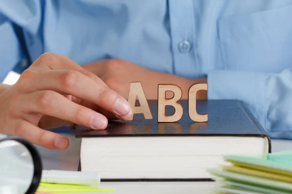 Хлопчик пише в школі блокнот, дерев'яні букви Abc на книгу — стокове фото