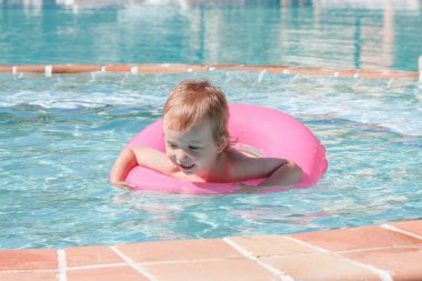 Küçük çocuk havuzda oynuyor.