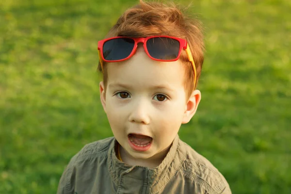 Söt rödhårig pojke i solglasögon. — Stockfoto