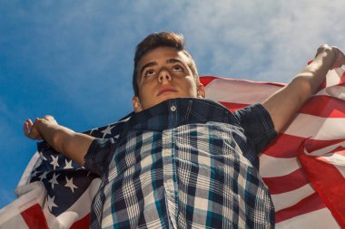 ABD bayrağı bir yaz gökyüzü arka planda çalışan bir adam tarafından düzenlenmektedir