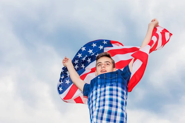 美国国旗举行由一个运行的家伙在夏日天空的背景 — 图库照片