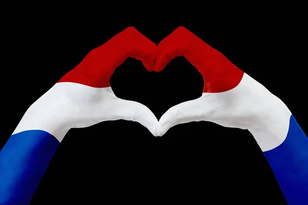 För Nederländerna, flagg på händer forma ett hjärta. Begreppet land symbol, isolerade på svart. — Stockfoto