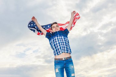 ABD bayrağı bir yaz gökyüzü arka planda çalışan bir adam tarafından düzenlenmektedir