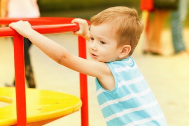 Parkta oynayan genç çocuk.