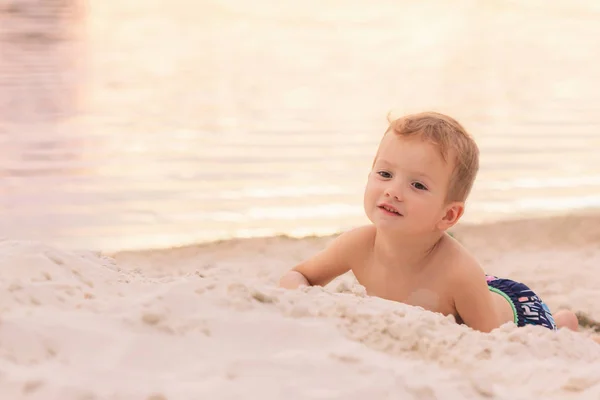 Niño descansando en una playa de arena —  Fotos de Stock