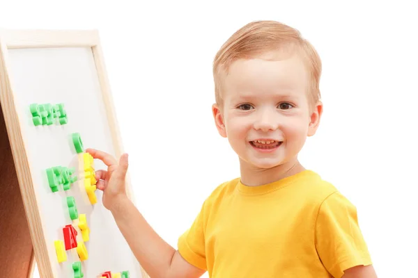 Kind an der Tafel mit Zahlen und Buchstaben erfindet Wörter. — Stockfoto