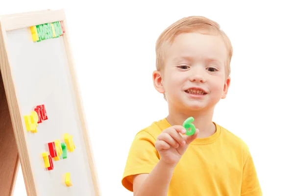 Kind an der Tafel mit Zahlen und Buchstaben erfindet Wörter. — Stockfoto
