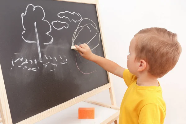 Cheerful smiling child at the blackboard. Stock Photo