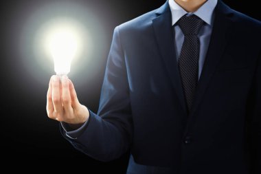 Kavramı, elinde tutan işadamı ampul işareti yanar..