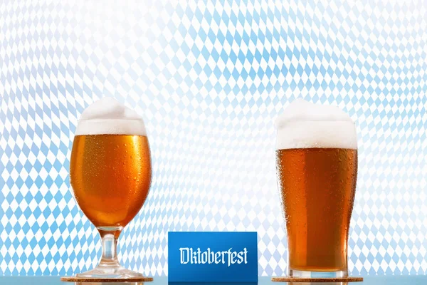 Oktoberfest Beer glass pint on Bavarian flag background with foam and festival text.