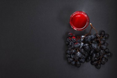 Mavi üzüm suyu ile siyah ahşap arka plan Üstten Görünüm.