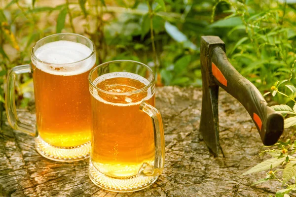 Beer mugs cheers on natural background.