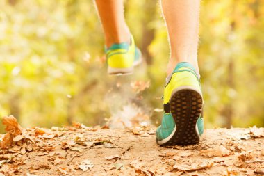 Atlet sonbahar ormanın içinden çalıştırmak bir sabah yapar. Yeşillik bir Parkı koşu bandı ve atlet ayağı.