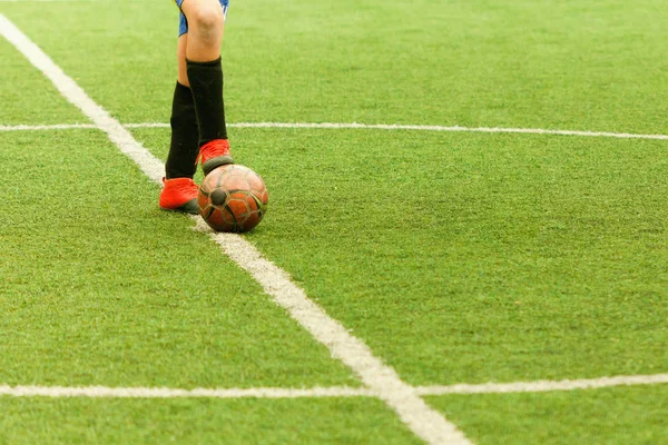 Jogador de campo para a frente com uma bola no campo de futebol central . — Fotografia de Stock