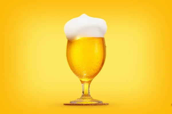 Vaso de cerveza en primer plano con espuma sobre fondo amarillo —  Fotos de Stock