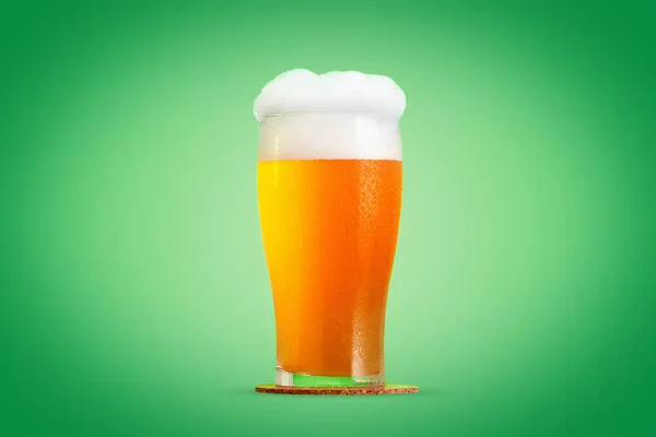 緑の背景の上の泡とビールのクローズ アップのガラス — ストック写真