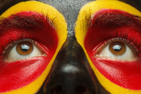 Eyes of German or Belgian sports fan patriot. Bandera de país pintada en la cara del hombre . —  Fotos de Stock
