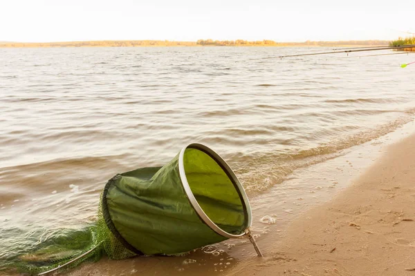 Canne da pesca e attrezzi da pesca sulla riva del fiume, costa del lago . — Foto Stock