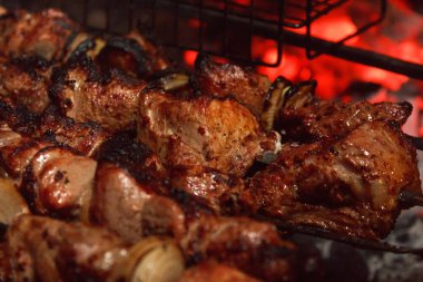 Fried sulu barbekü et yemek yemek bir şenlik ateşi üzerinde yangın bir ızgara